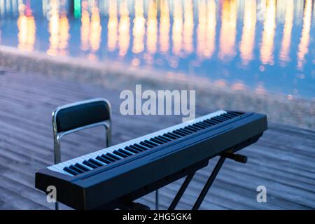 Der Synthesizer steht mit Spiegelung am Flussufer Stockfoto