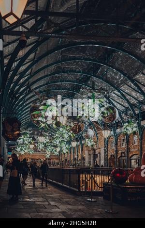 London, Großbritannien - 23. November 2021: Weihnachtsschmuck, Mistel und riesige Festkugeln auf dem Covent Garden Market, einem der beliebtesten Touristenattraktionen Stockfoto