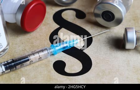 Nahaufnahme des Absatzsymbols mit Impfspritze und Fläschchen – obligatorisches Impfkonzept (Fokus auf den blauen Teil der Spritze) Stockfoto