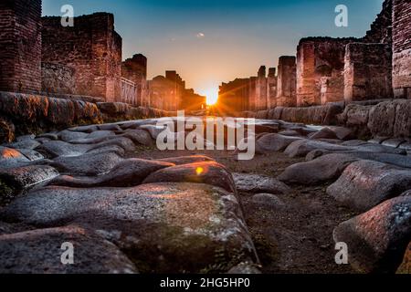 Sonnenuntergang in der antiken Stadt pompeji. Low-Angle-Aufnahme in der Mitte der Straße. Stockfoto