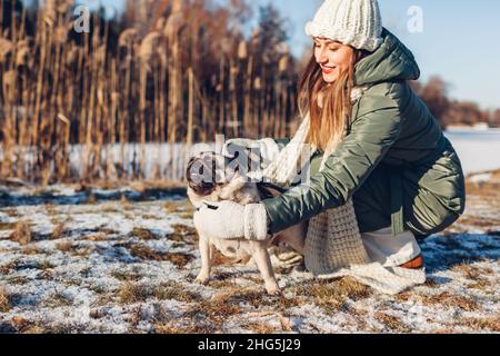 Junge Frau, die im verschneiten Winterpark mit einem Haustier spielt, geht mit einem Schwabenhund spazieren. Saisonale Aktivitäten im Freien mit Tieren Stockfoto