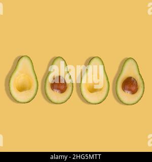 In Scheiben geschnittene Avocado auf pastellgelbem Hintergrund. Draufsicht. Banner. Pop-Art-Design, kreatives sommerliches Food-Konzept. Grüne Avocados, minimalistischer, flacher Lay-Style. Co Stockfoto