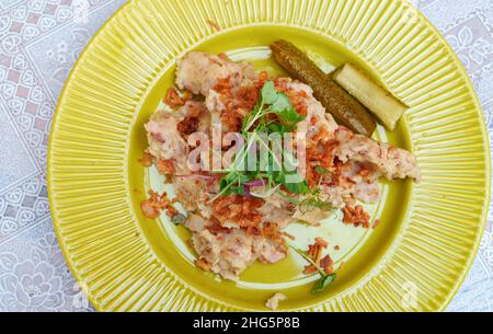 Kartoffelpüree mit Knistern auf einem gelben Teller. Stockfoto