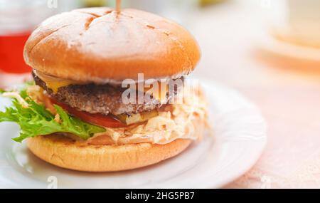 Rustikaler Hamburger mit geschmolzenem Käse und Rinderschnitzel. Stockfoto