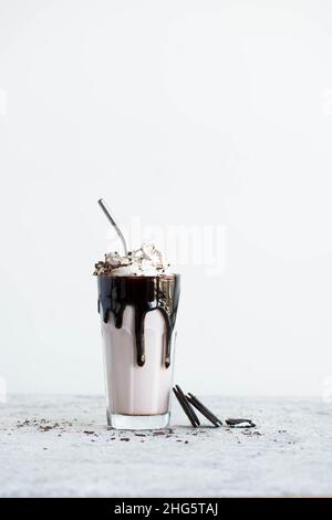 Schokoladen-Milchshake mit Schlagsahne und Schokoladenstückchen. Stockfoto