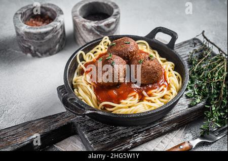 Vegane Tomatenpasta mit Fleischbällchen auf pflanzlicher Basis in einer Pfanne. Weißer Hintergrund. Draufsicht Stockfoto