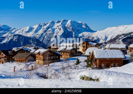 Alpe d'Huez, Frankreich - 31.12.2021: Winterlandschaft mit Holzchalet im französischen Skigebiet. Fabelhafter Winterblick auf die alpes Berge. Hintergrund des Urlaubskonzepts. Fotos in hoher Qualität Stockfoto