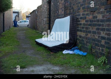 Alte Matratze wurde illegal hinter einigen Häusern abgekippt Stockfoto