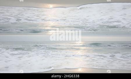 Wunderschöne Meereslandschaft mit Horizont-Spiegel-Effekt mit Wellen, die am Ufer krachen. Endlose Wellen mit Sonnenreflexion auf der Wasseroberfläche, Thema der Entstehung Stockfoto