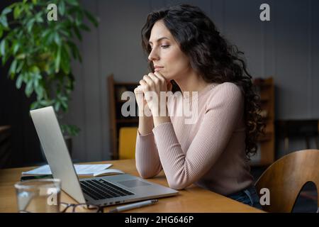 Fokussierte Geschäftsfrau, die am Laptop arbeitet, Buchhalterin, die elektronische Finanzdokumente liest Stockfoto