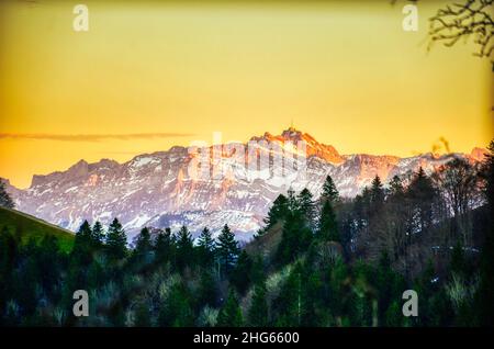 Sonnenuntergang in den Bergen. Der Santis-Berg in den Appenzeller Alpen leuchtet im letzten Licht. Schnee auf dem Gipfel. Stockfoto