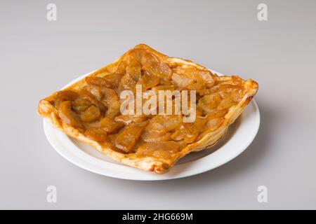 Ein Stück karamellisierter Birnenkuchen auf einem weißen Teller. Das Konzept des Minimalismus. Stockfoto