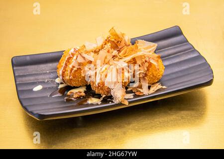 Takoyaki ist ein japanisches Essen aus Weizenmehl und Tintenfisch. Es wird in Form eines Balls hergestellt. Seine Zutaten sind: Weizenmehl-Teig mit Wasser, Stockfoto