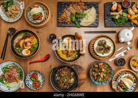 Asiatische und japanische Gerichte mit verschiedenen Ramen, gebratener Ente, bao-Pfanne, Wok-Nudeln, Sojasauce, Pilze und Vorspeisen Stockfoto