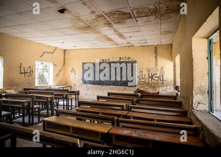 Maiduguri, Nigeria. 24th. November 2021. Ein Junge sah, wie er in einem leeren Klassenzimmer der Moduganari-Grundschule auf einem Schreibtisch lag.der Nordosten von Nigeria erlebt seit 2009 einen Aufstand, der zu 2,4 Millionen Vertriebenen geführt hat und etwa die Hälfte der Schüler die Schulbildung verlassen musste. (Foto: Sally Hayden/SOPA Images/Sipa USA) Quelle: SIPA USA/Alamy Live News Stockfoto