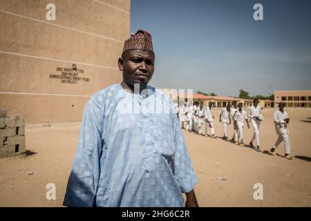 Maiduguri, Nigeria. 24th. November 2021. Baba Ganae A'aj, Schulleiterin der Grundschule der Regierung Moduganari, wird neben einer Reihe von Schülern gesehen.der Nordosten von Nigeria erlebt seit 2009 einen Aufstand, der zu 2,4 Millionen Vertriebenen geführt hat und etwa die Hälfte der Schüler die Bildung verlassen musste. (Foto: Sally Hayden/SOPA Images/Sipa USA) Quelle: SIPA USA/Alamy Live News Stockfoto