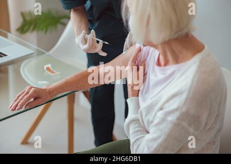 Ältere Frau, die sich zu Hause impfen ließ Stockfoto