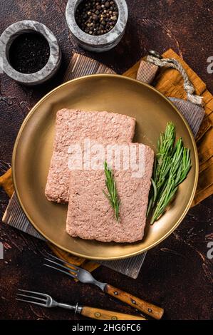 Frisches vegetarisches Hackfleisch, rohes Fleisch auf pflanzlicher Basis mit Rosmarin. Dunkler Hintergrund. Draufsicht Stockfoto