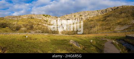 Malham Cove ist eine riesige, geschwungene, Amphitheater-förmige Felsformation aus Kalkstein. Die senkrechte Seite der Klippe ist etwa 260 Meter hoch. Stockfoto