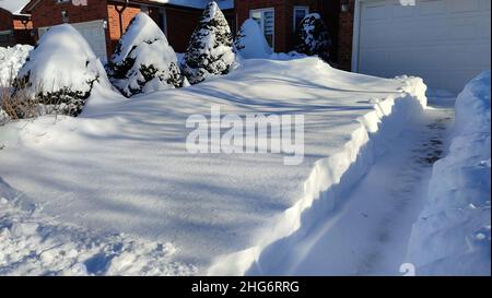 Die Auffahrt ist in Kanada für ein Wetter- oder Schneesturm-Konzept mit tiefweißem Schnee bedeckt. Stockfoto