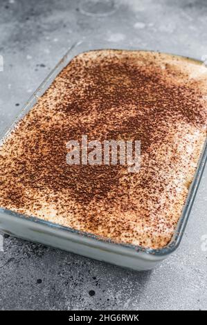 Tiramisu Italienisches Dessert mit Kakao gekrönt. Grauer Hintergrund. Draufsicht Stockfoto