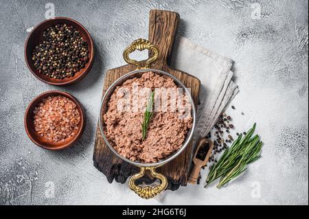 Ungekochte vegane Hackfleisch, rohes Fleisch auf pflanzlicher Basis mit Thymian in Pfanne. Weißer Hintergrund. Draufsicht Stockfoto