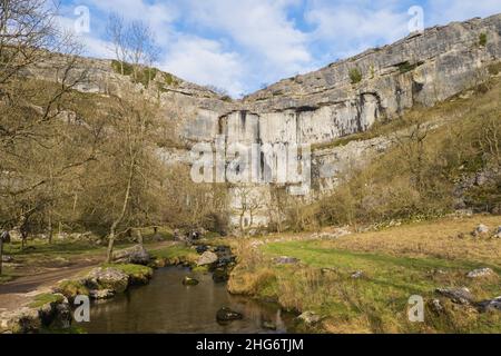 Malham Cove ist eine riesige, geschwungene, Amphitheater-förmige Felsformation aus Kalkstein. Die senkrechte Seite der Klippe ist etwa 260 Meter hoch. Stockfoto