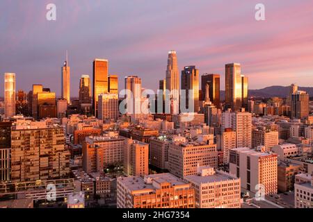 Luftaufnahme eines erstaunlichen rosa und goldenen Sonnenaufgangs, der sich in den Türmen der Innenstadt von Los Angeles widerspiegelt Stockfoto