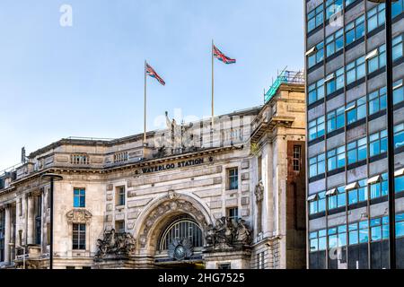London, UK Schild für Waterloo Bahnhof historische Architektur Außenfassade an sonnigen Tagen und Union Jack Fahnen blauen Himmel mit niemand Stockfoto