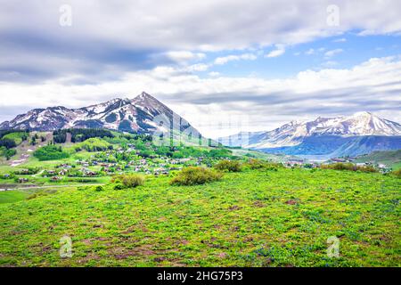 Mount Crested Butte in Gunnison County Open Panoramablick mit Wiese Feld Sommer Delphinium Wildblumen Festival Stadtbild der Stadt Häuser felsigen Moun Stockfoto