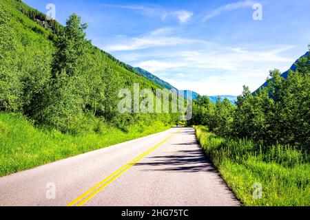 Maroon Creek Road Trip bei Maroon Bells in Aspen, Colorado Rocky Mountains und Sommer üppig grünes Laub fahren Auto Sicht leere Straße Stockfoto