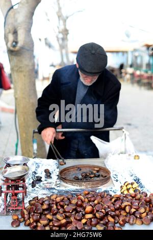 Ein türkischer Mann, der Kastanien auf der Straße in Üsküdar, Istanbul, Türkei, röstet. Stockfoto