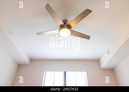 Leeres Schlafzimmer Zimmer innen niemand blickte aus dem Winkel auf beleuchtet gelbes Licht Deckenventilator Fenster in neuen modernen Luxus-Wohnung Haus ho Stockfoto