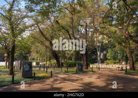 Die keramischen Fliesen mit Kirschblüte und der Yasukuni-Uhrenturm im seelenberuhigenden Garten am Äußeren Garten des Yasukuni-Schreines. Tokio. Japan Stockfoto