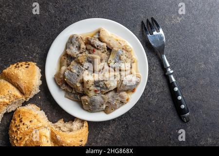 Gehackter marinierter Fisch. Gesalzener Hering auf dem Teller. Stockfoto