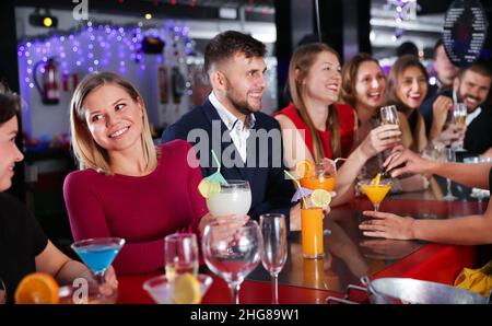 Frau mit Kollegen genießen die Firmenfeier in der Bar Stockfoto