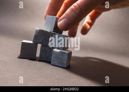 Whiskey-Steine stehen auf einem grauen Hintergrund. Steine zum Kühlen von Getränken. Stockfoto