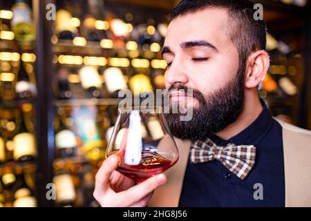 ein arabischer Sommelier, der ein Getränk im Luxe Hotel zu schätzen weiß Stockfoto