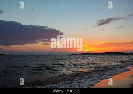 Farbenfroher, wolkiger Sonnenuntergang an der Küste von Korfu. Die Sonne geht über den Horizont mit dem Ionischen Meer in Griechenland unter. Stockfoto