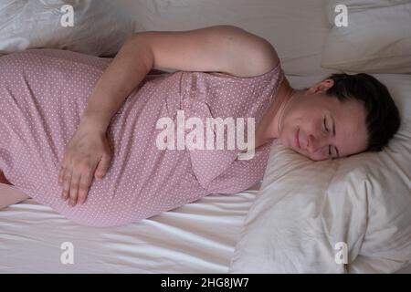 Schwangere Frau schlafen friedlich im Schlafzimmer Stockfoto