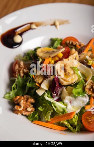 Nahaufnahme eines Salats mit Nüssen und Bananen. Vertikales Bild Stockfoto