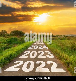 Neujahr 2022 Ziele Konzept : Leere Asphaltstraße Sonnenaufgang mit Text gehen Sie zu Neujahr 2022 Stockfoto