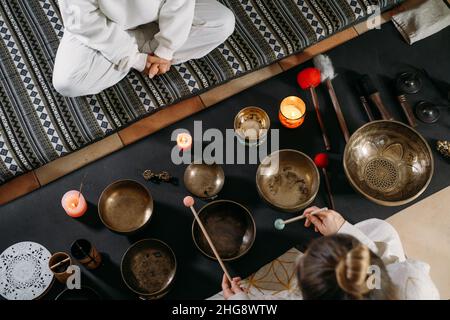 Gesangsschalen Draufsicht, Klangheilung alternative Therapie. Frau spielt auf Percussion Metal Musikinstrumenten. Psychische Gesundheit mit Meditation Stockfoto