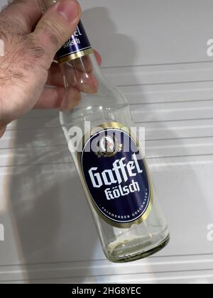 Paris, Frankreich - 7. Jan 2022: POV männliche Hand hält Empy Flasche mit Gaffel Kolsch deutsches Bier Stockfoto