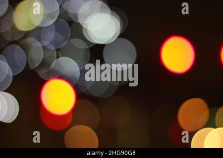 Wunderschöne bunte Bokeh-Kugeln hüpfen herum als Lichter der Stadt. Stockfoto