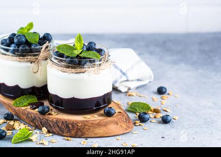 Parfait mit Heidelbeere, Müsli und Marmelade in zwei Gläsern. Stockfoto