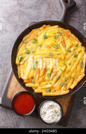 Tansanische Spezialgericht Chips Mayai French Fries Omelett Nahaufnahme in den Teller auf dem Tisch. Vertikale Draufsicht von oben Stockfoto