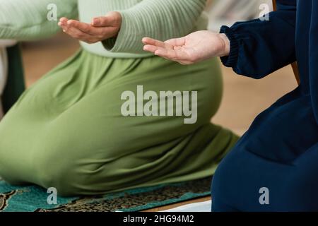 Beschnittene Ansicht muslimischer Frauen, die zu Hause beten Stockfoto