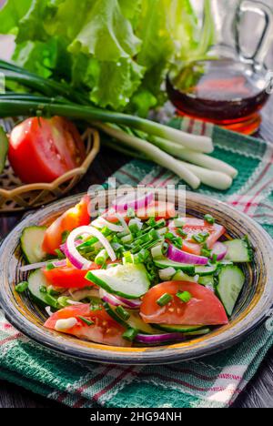 Diätsalat mit frischen Gurken, Tomaten und jungen Zwiebeln Stockfoto