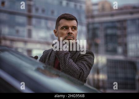 Porträt eines nachdenklichen reichen Mannes vor einem Geschäftszentrum. Stockfoto